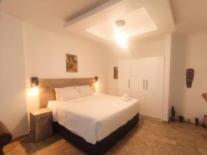 a bedroom with a large white bed in a room at Michelangelo - Zur See in Ballito