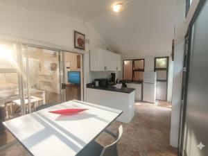 a kitchen with a white table and a red bowl on it at Michelangelo - Zur See in Ballito