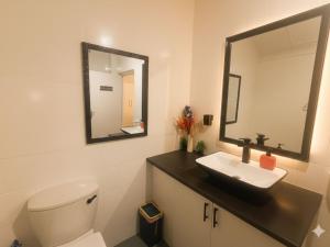 a bathroom with a toilet and a sink and a mirror at Michelangelo - Zur See in Ballito +6 photos
