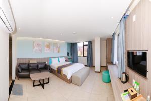a bedroom with a bed and a couch and a tv at Tina 5 hotel cần thơ in Ấp Phú Thạnh (4)