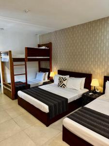 two beds in a room with two bunk beds at Lakambini Transient in El Nido