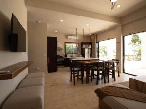 a kitchen and dining room with a table and chairs at Casa Norte – Oceanfront Villa in Placencia