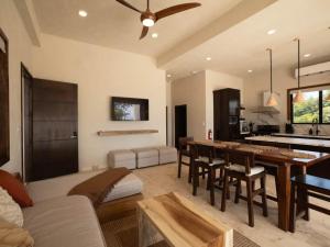 a kitchen and living room with a table and chairs at Casa Norte – Oceanfront Villa in Placencia