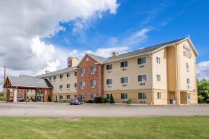 a large building with a car parked in a parking lot at Comfort Suites Wisconsin Dells Area in Portage