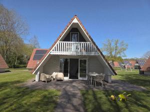 a house with a white roof and a table and chairs at Groene Specht 16 in Gramsbergen