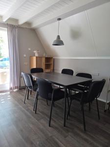 a dining room with a black table and chairs at Groene Specht 16 in Gramsbergen