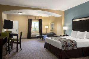 a hotel room with a bed and a desk at Days Inn & Suites by Wyndham Gonzales TX in Gonzales