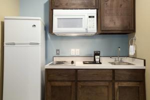 a kitchen with a sink and a microwave at Days Inn & Suites by Wyndham Gonzales TX in Gonzales +14 photos