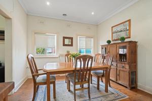 a dining room with a wooden table and chairs at Red Brick Beauty - Central Cottage in Albury