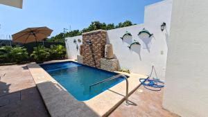 a swimming pool in the backyard of a house at Bungalows Huerta del Mar in San Blas