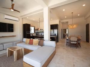 a living room with a white couch and a table at Casa Sur – Oceanfront Villa in Placencia
