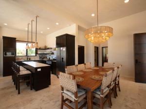 a kitchen and dining room with a wooden table and chairs at Casa Sur – Oceanfront Villa in Placencia