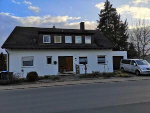 a white house with a car parked in front of it at Appartment Schlossblick in Wiesenthau +23 photos