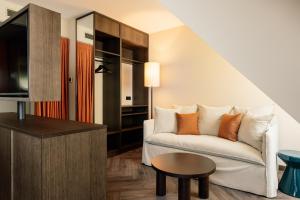 a living room with a couch and a table at Hotel Schani City in Vienna