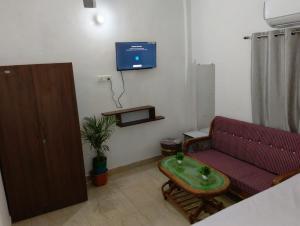 a living room with a couch and a tv on the wall at Hotel Vasu in Gopālganj +19 photos