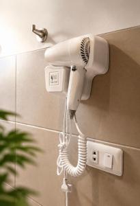 a white hair dryer hanging on a wall at Bella Athena Garden in El Nido