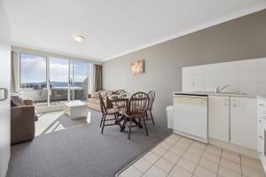 a kitchen and living room with a table and chairs at Horizons 302 in Jindabyne +7 photos