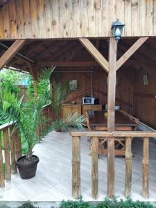 a large wooden pavilion with a table and potted plants at Casa Cami in Jurilovca