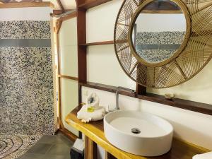 a bathroom with a sink and a mirror at Fare Oviri Lodge in Opoa +73 photos