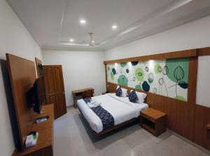 a bedroom with a bed and a television in it at Sneha Inn in Kannur