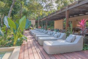 a row of white couches on a wooden deck at Aldea Mayab Luxury Residences by Lagoona in Bacalar