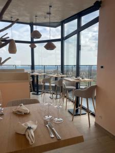 a dining room with tables and chairs and windows at Wasserturm Hotel Elsenborn in Butgenbach