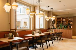 a restaurant with tables and chairs and chandeliers at Hotel Schani City in Vienna