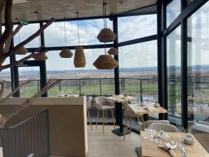a restaurant with tables and chairs and large windows at Wasserturm Hotel Elsenborn in Butgenbach
