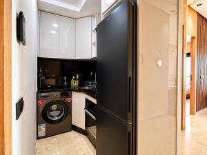 a black refrigerator in a kitchen with a washing machine at Oasis Hills - Modern & Cosy 1BR with Balcony - Central in Casablanca
