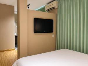 a bedroom with a bed and a television on a wall at Mansion Inn Sibu in Sibu