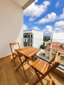 a wooden table and chairs on a balcony with a view at Oasis Hills - Modern & Cosy 1BR with Balcony - Central in Casablanca