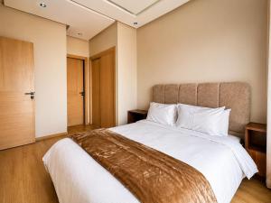 a bedroom with a large bed with white sheets at Oasis Hills - Modern & Cosy 1BR with Balcony - Central in Casablanca