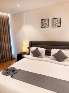 a bedroom with two beds with white sheets and pillows at The Residence by Chakolas Pavilion in Cochin