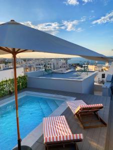 a balcony with a swimming pool and an umbrella at The Duchess of Puglia in Polignano a Mare