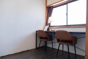 two chairs sitting at a desk in a room with a window at 白灯-Hakuto- Ishiuchi in Minami Uonuma +21 photos