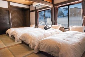 three beds in a room with large windows at 白灯-Hakuto- Ishiuchi in Minami Uonuma