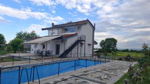 a house with a swimming pool in front of a building at Alesta Apartment in Tríkala