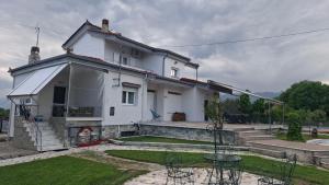 a white house with stairs and a yard at Alesta Apartment in Tríkala