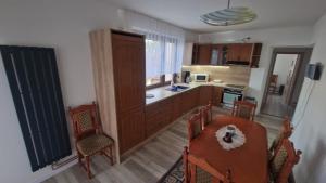 a kitchen with wooden cabinets and a table and chairs at Apartment LAURA in Žilina