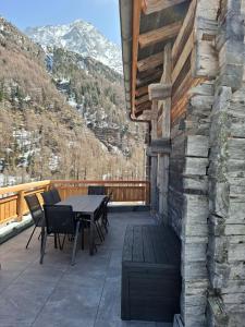 a patio with a table and chairs and mountains at Chalet La Grange à Philippe in Evolène +19 photos