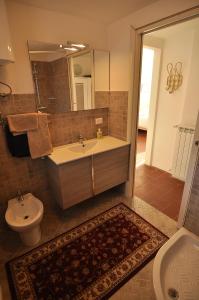 ein Badezimmer mit einem Waschbecken, einem WC und einem Spiegel in der Unterkunft Alla Cantina in Aurisina Case