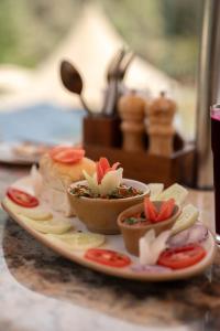 a plate of food on a table with bowls of food at Saraaya Glamps, Dharamshala in Dharamshala