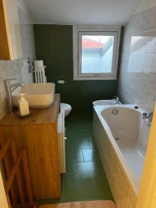 a bathroom with a tub and a sink and a toilet at NK House in Pero