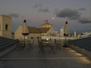 a group of tables and umbrellas on a roof at The Duchess of Puglia in Polignano a Mare
