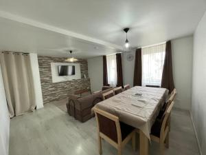 a dining room with a table and a living room at Maison 3 chambres - Parking privé in Gandrange
