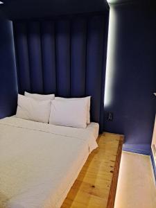 a large bed with a blue headboard in a room at 김천747모텔 in Pusang
