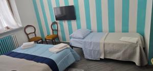 a room with two beds and a flat screen tv at Residenza dei pini lacchiarella in Lacchiarella