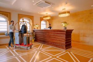 a man standing in a lobby with a luggage cart at Hotel Aurea Jaisalmer in Jaisalmer +94 photos