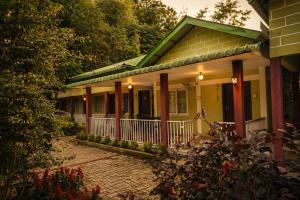 ein Haus mit Veranda und davorliegendem Steinweg in der Unterkunft Bononi in Jorhat