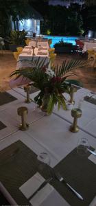 a table with a white table cloth and a plant on it at Maison Carrée Andilana in Andilana +28 photos